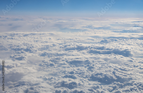 View from a high altitude on the clouds and the earth, the movement of air masses. Concept: God's view of the earth, the view from the plane window.