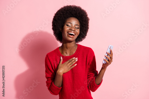 Portrait of attractive dreamy cheerful girl using gadget laughing having fun isolated over pink pastel color background
