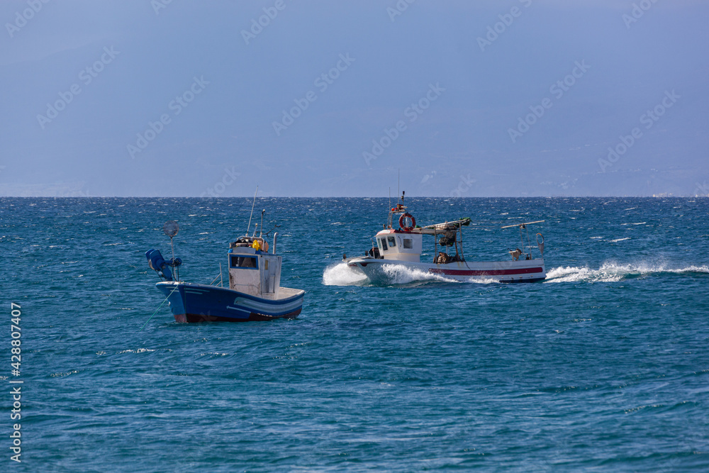 Fishing boats comes back to the coast, Almeria, Spain.