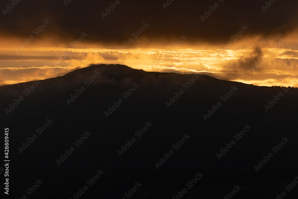 Photograph of breathtaking summer sunset landscapes, mountainous, misty and full of clouds, on the Galician coast, Ortigueira, near Cape Ortegal, La Coruña province, Spain.