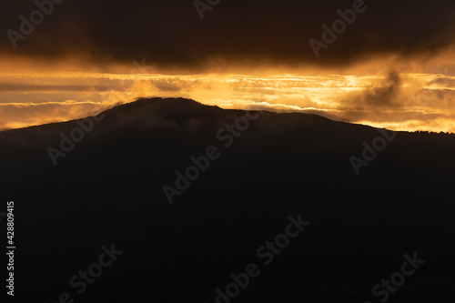 Photograph of breathtaking summer sunset landscapes, mountainous, misty and full of clouds, on the Galician coast, Ortigueira, near Cape Ortegal, La Coruña province, Spain.