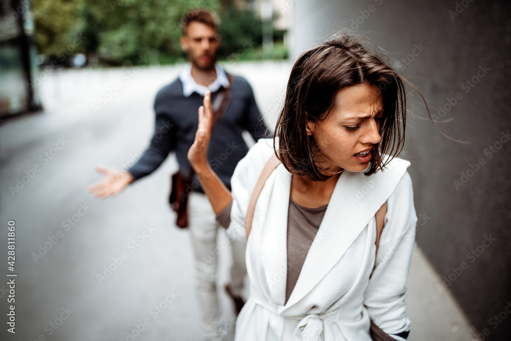 Sad young woman and man outdoor on street having relationship problems Sad young woman and man outdoor on street having relationship problems