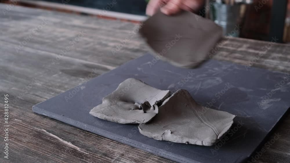 A female sculptor lays out pieces of clay on the table with her hands, prepares the material for modeling ceramics. Close-up, no face, 4K, 25 fps A female sculptor lays out pieces of clay on the table with her hands, prepares the material for modeling ceramics. Close-up, no face, 4K, 25 fps
