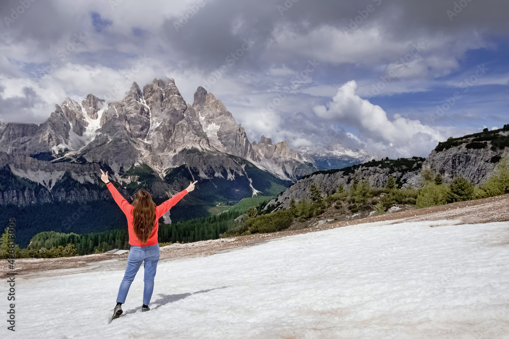 Woman traveller hiking in Dolomite Alps mountains.
