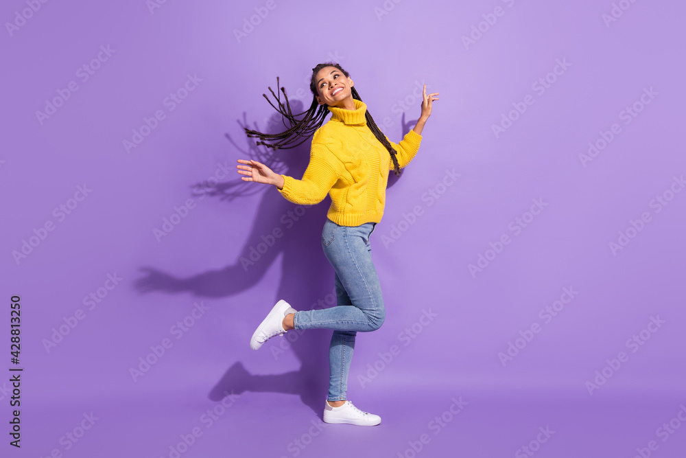 Full size profile photo of optimistic funky brunette girl dance wear sweater jeans sneakers isolated on purple background