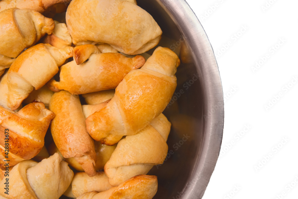 Croissants. Fresh homemade cakes in a heap in a metal dish on a white isolated background. Buns Croissants. Fresh homemade cakes in a heap in a metal dish on a white isolated background. Buns