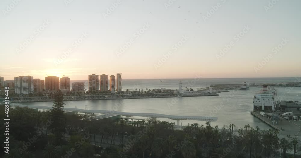 Aerial shot of Malaga Harbor with parking ship and skyline during epic sunset in backdrop. Aerial shot of Malaga Harbor with parking ship and skyline during epic sunset in backdrop.