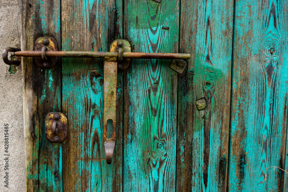 Old, green, wooden doors to farm buildings, with steel fittings. Poor lighting conditions Old, green, wooden doors to farm buildings, with steel fittings. Poor lighting conditions