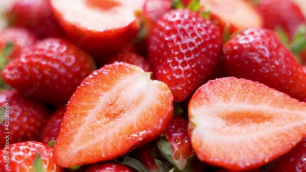 Juicy Red Strawberries Decorated With Sliced Strawberry Slices, Macro, Rotate. Isolated. Healthy Vegan Food. Background of Fresh Strawberries and Strawberry Slices. Juicy Red Strawberries Decorated With Sliced Strawberry Slices, Macro, Rotate. Isolated. Healthy Vegan Food. Background of Fresh Strawberries and Strawberry Slices.