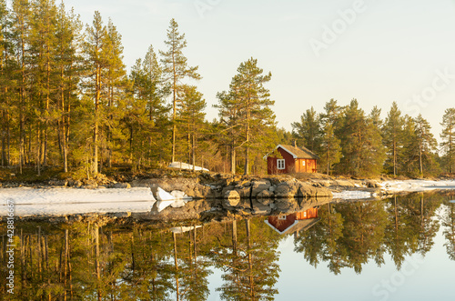 Typical Scandinavian-style holiday home in a forest by the lake called hytte photo