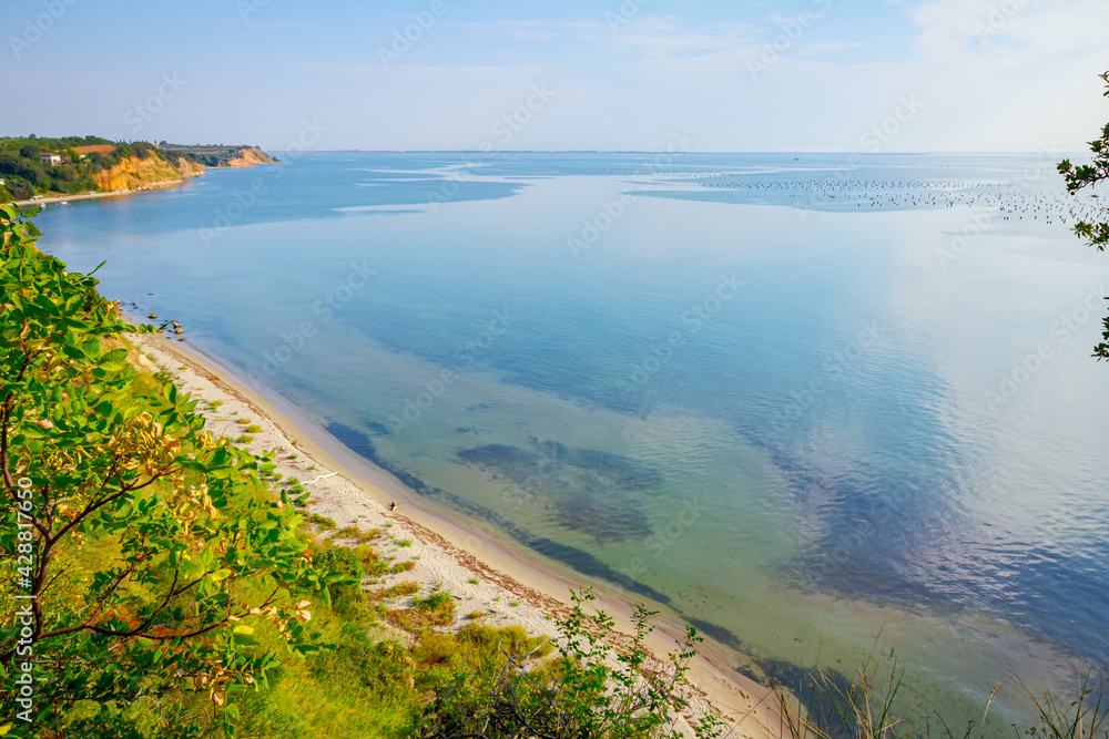 Cliff with vegetation above idyllic and peaceful bay Cliff with vegetation above idyllic and peaceful bay