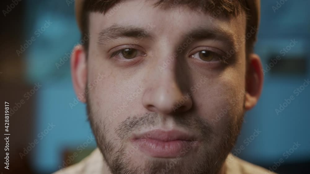 Portrait of young sad man with brown eyes, looking in camera with joyless, sorrowful view. Close-up of male face student having stubble beard. Portrait of young sad man with brown eyes, looking in camera with joyless, sorrowful view. Close-up of male face student having stubble beard.