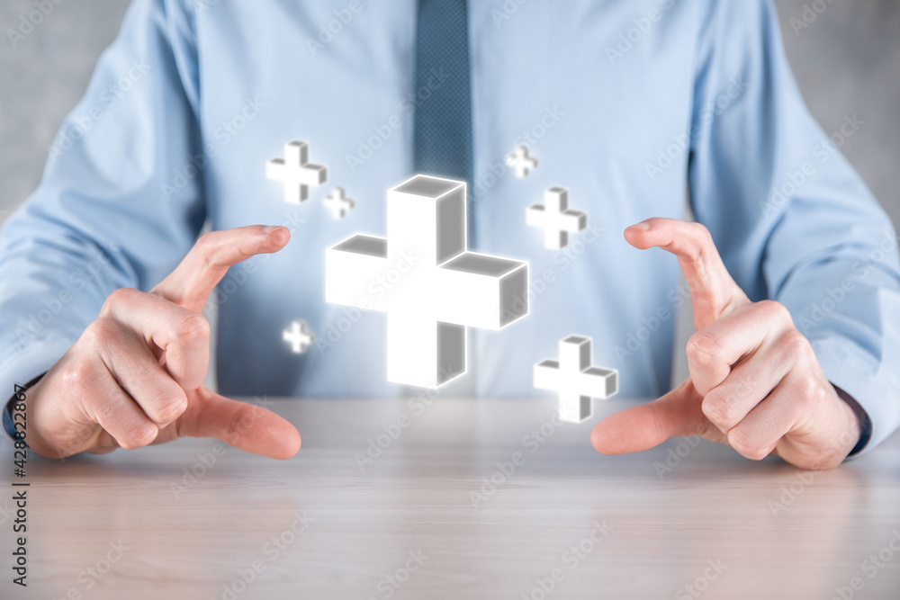 Businessman hold 3D plus icon, man hold in hand offer positive thing such as profit, benefits, development, CSR represented by plus sign.The hand shows the plus sign Businessman hold 3D plus icon, man hold in hand offer positive thing such as profit, benefits, development, CSR represented by plus sign.The hand shows the plus sign