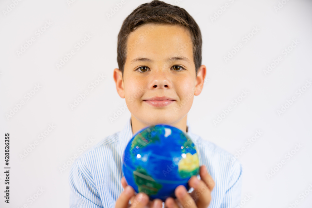 Closeup portrait of school boy holding a world globe isolated over white background Closeup portrait of school boy holding a world globe isolated over white background