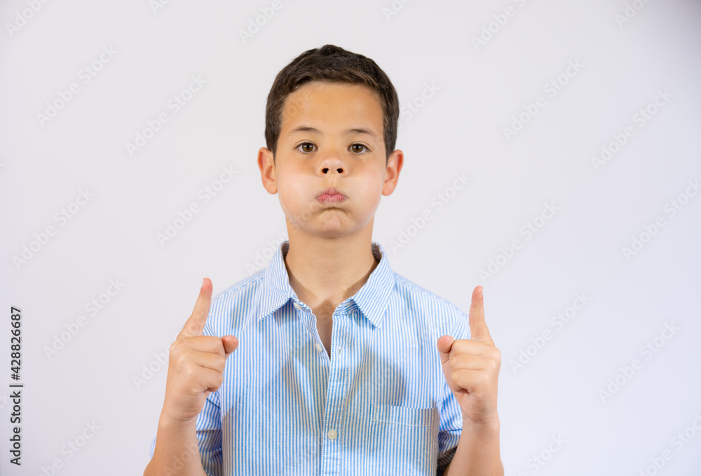 Cheerful funny boy pointing up over white background Cheerful funny boy pointing up over white background