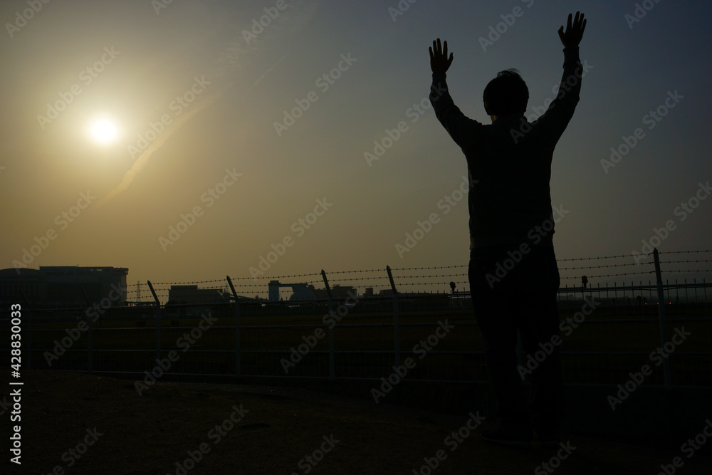 Silhouette man rising hands up on sunset sky and clouds abstract background - 手をあげる男性 夕陽の背景