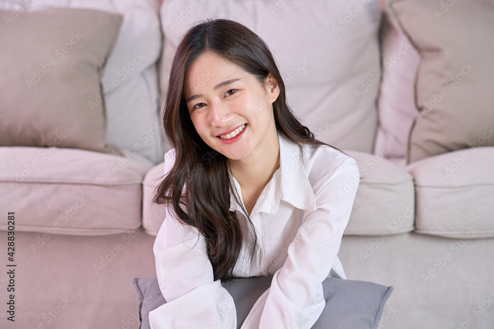 Cute Asian girl smile near sofa at home Cute Asian girl smile near sofa at home
