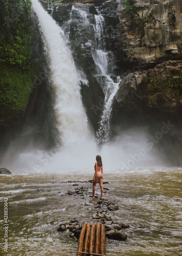 Beautiful girl having fun at the waterfalls in Bali. Concept about wanderlust traveling and wilderness culture