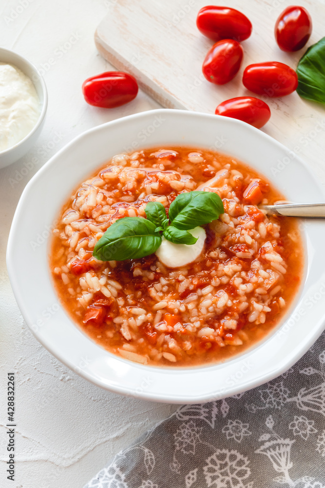 Tomato soup with rice decorated by cream and basil leaf. Tomato soup with rice decorated by cream and basil leaf.