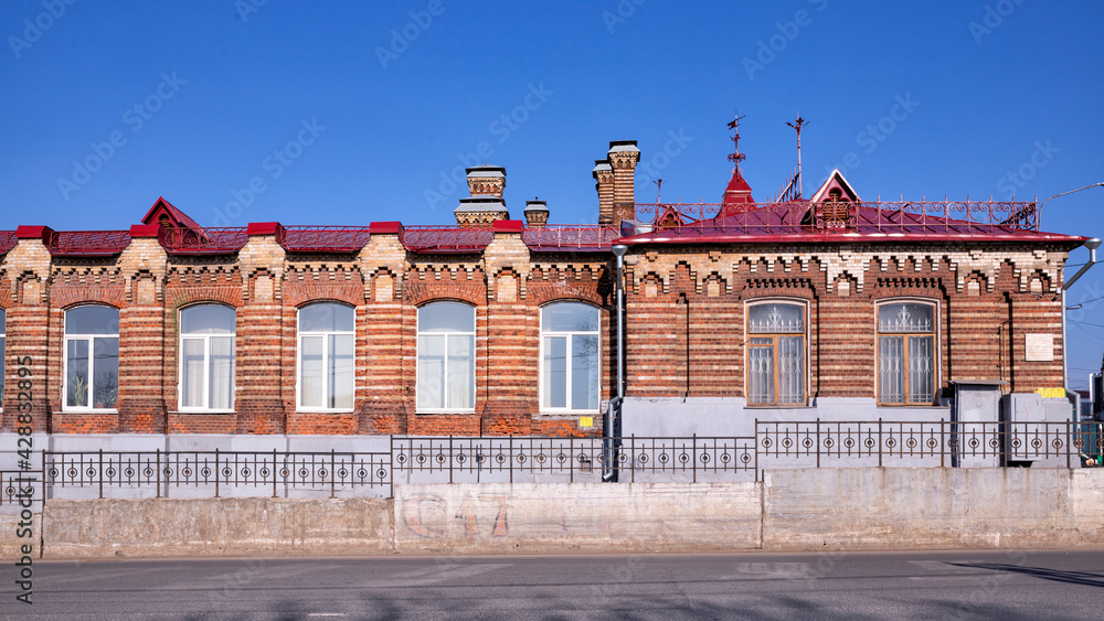 Vintage architecture classical facade historic red brick one-story building front view.