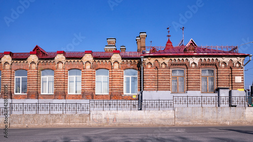 Vintage architecture classical facade historic red brick one-story building front view.