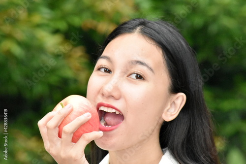 An Asian Woman Eating An Apple