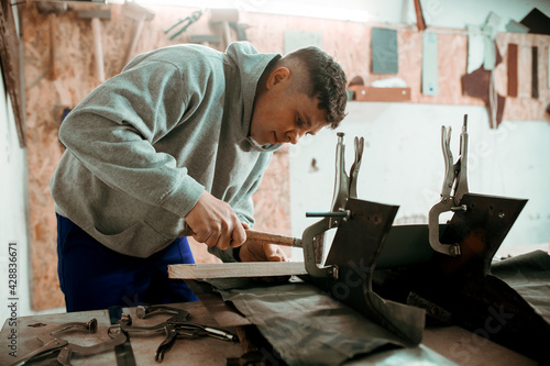 Photos Professional tinsmith working with metal, workshop
