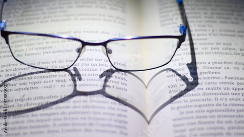 Ombre de lunettes en forme de c  ur sur un livre