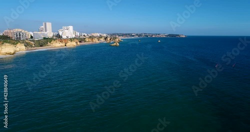 Scenic aerial view of the coastline near the Praia da Rocha (Rocha Beach), with windsurfers, in Portimao, Algarve, Portugal