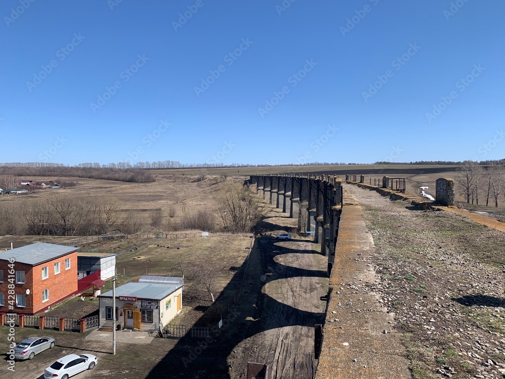 view from the old abandoned viaduct to the vastness and the village and blue sky view from the old abandoned viaduct to the vastness and the village and blue sky