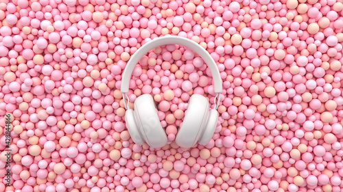 A white headphone on soft pink balls. Minimal musical flat lay concept. Advertisement ASMR idea. 3d render