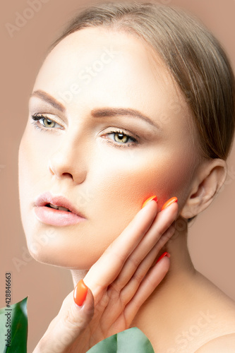 Close-up beauty portrait of model woman with makeup, healthy clean perfect skin over beige background