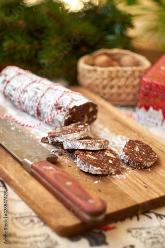 Chocolate salami on a wooden board. Christmas decor. Side view.
