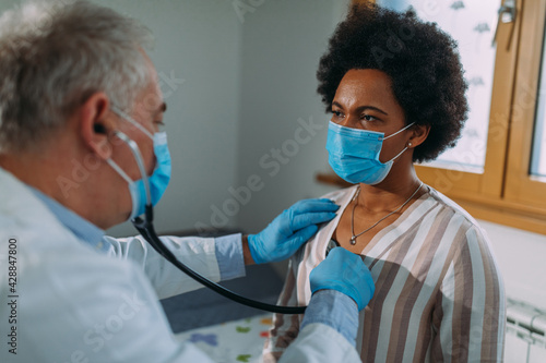 Portrait of doctor listening to patient's lungs