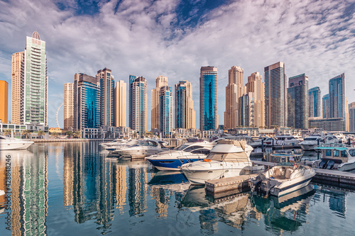 Photography yacht and motor boats parking at the port near Dubai Marina Mall with row of hig