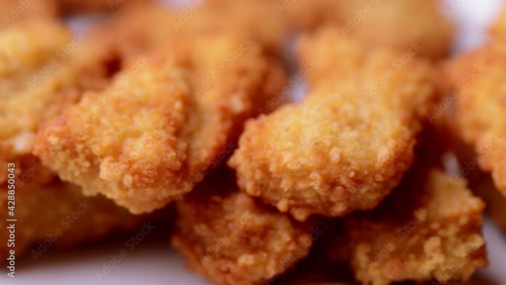 macro closeup of chicken nuggets snacks rotating spinning on a dish macro closeup of chicken nuggets snacks rotating spinning on a dish
