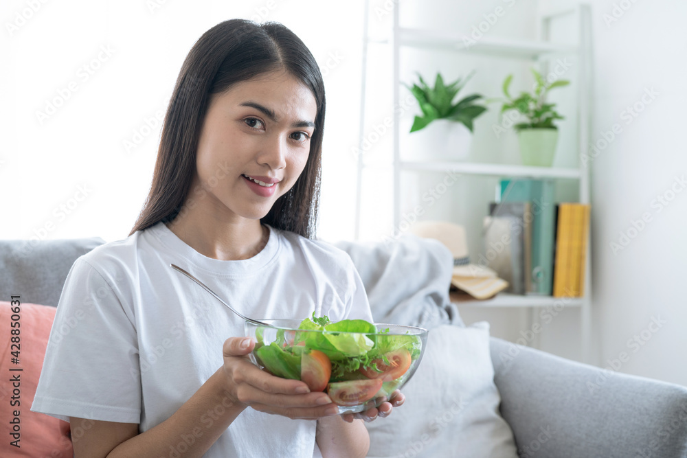 Young happy Asian woman eating healthy salad. Young happy Asian woman eating healthy salad.