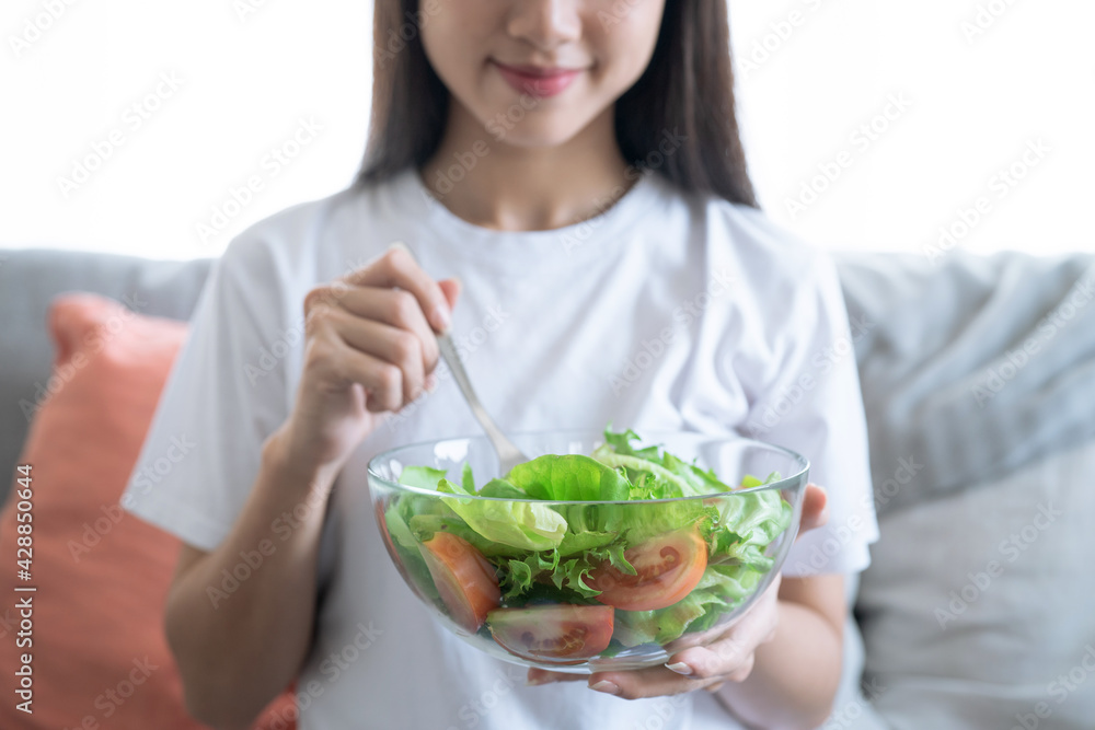Young happy Asian woman eating healthy salad. Young happy Asian woman eating healthy salad.