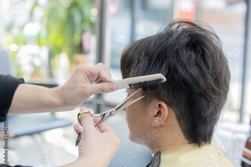 Hairdresser Cutting Customer Hair with Scissor