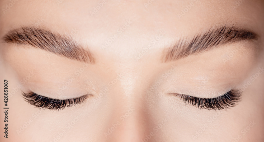 Naklejka premium Woman eye with beauty black lashes. Eyelash extension procedure top view