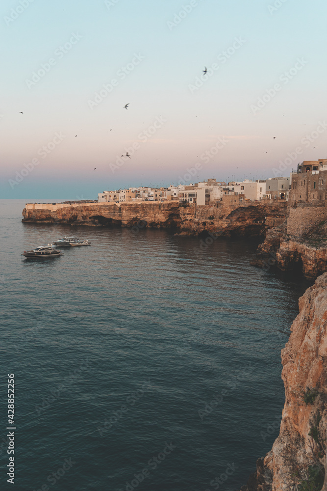 Polignano a Mare in Puglia with birds by sunset