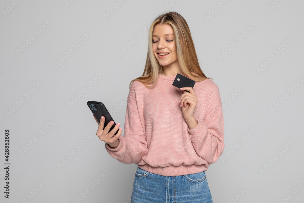 Portrait of a smiling woman holding smartphone over white background