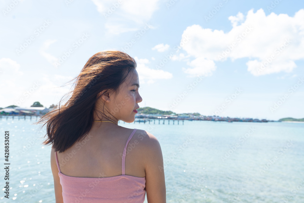 Medium shot Back of asian woman tan skin wearing pink tank top and Facing side. Summer travel. Relaxing, Holiday and tropical Alone concept.