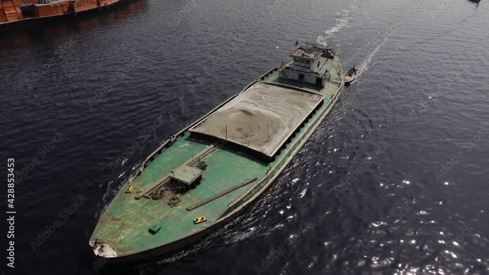A trawler full loaded with sand is crossing the river Buriganga at shwarighat, Old Dhaka. Slowmotion video. A trawler full loaded with sand is crossing the river Buriganga at shwarighat, Old Dhaka. Slowmotion video.