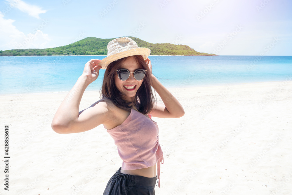 Face of young woman wearing pink tank hold straw hat wearing sunglasses. Happy woman smiling during summer vacation at sea. Beautiful lady relaxing at beach. fresh sky. Holiday, tropical, comfortable Face of young woman wearing pink tank hold straw hat wearing sunglasses. Happy woman smiling during summer vacation at sea. Beautiful lady relaxing at beach. fresh sky. Holiday, tropical, comfortable