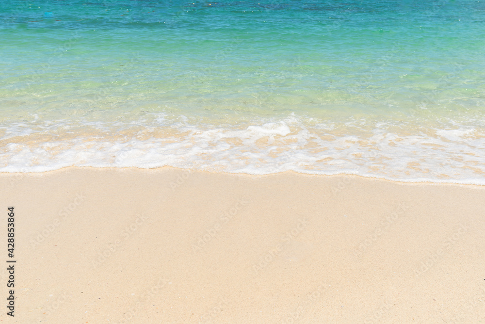 Beautiful clear sand beach and tropical light blue sea. Soft wave of blue ocean on sandy beach. Sallow water, Clear water. Seaside.