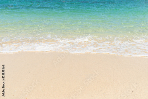 Beautiful clear sand beach and tropical light blue sea. Soft wave of blue ocean on sandy beach. Sallow water, Clear water. Seaside.