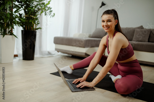 Young smiling girl wearing sportswear and preparing for home workout.