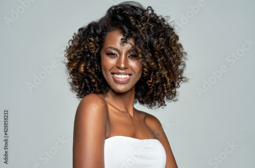 Close-up face of happy young african american woman over gray background