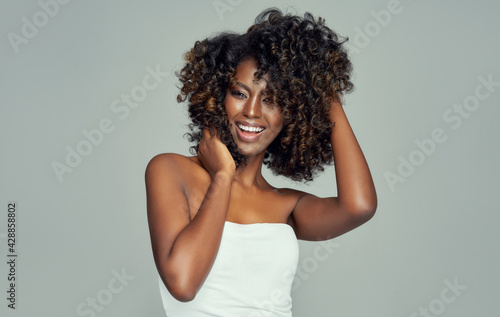Portrait of cheerful black woman isolated on gray background